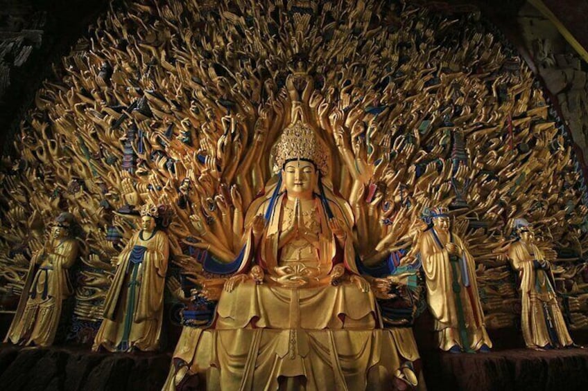 Une grande statue dorée représentant une figure assise, entourée de nombreuses autres figures, plus petites. 1