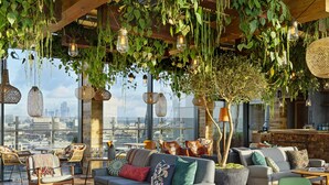 A rooftop lounge with a city view, featuring a mix of seating areas, hanging lights, and a bar. - Treehouse Hotel London (London)