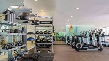 Un gimnasio con pesas rusas, balones medicinales y cintas de correr.