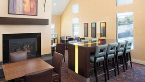A hotel lobby with a fireplace, a bar area, and multiple seating options. - Residence Inn By Marriott Binghamton (Vestal)