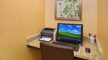 A desktop computer with a monitor, keyboard, and mouse on a granite countertop. A printer is also visible on the counter.