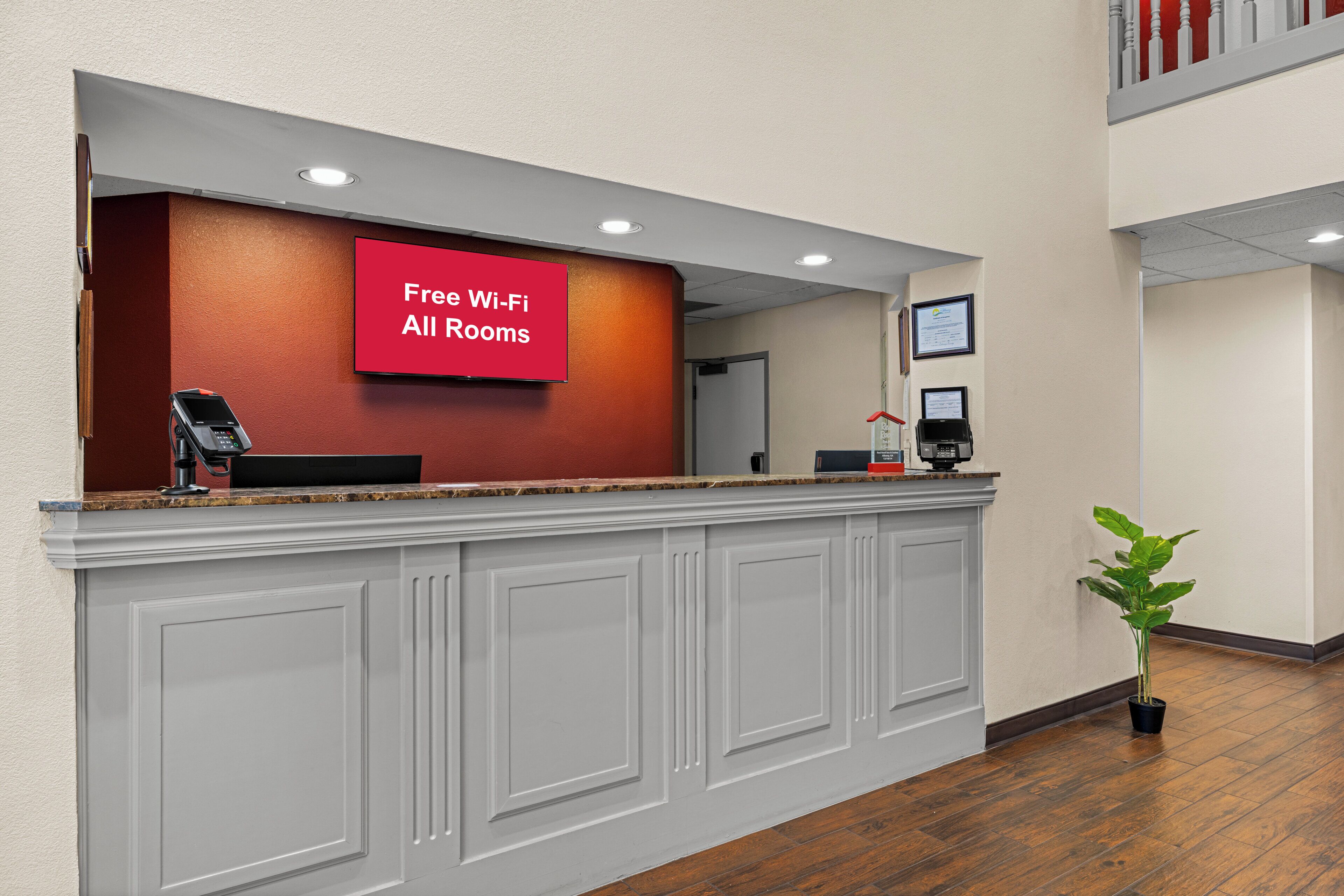 Un comptoir d’accueil avec un panneau rouge indiquant que le Wi-Fi est disponible gratuitement.