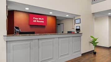 Un comptoir d’accueil avec un panneau rouge indiquant que le Wi-Fi est disponible gratuitement.