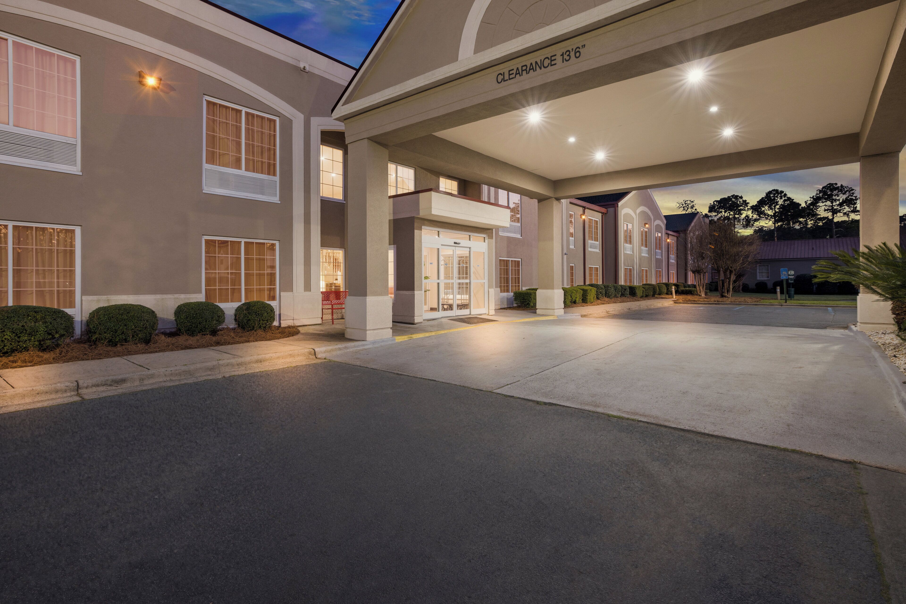 A hotel entrance with a clear sign indicating a clearance of 13'6'.