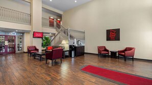 Un hall d'hôtel avec un escalier, un espace salon et une enseigne Red Roof Inn.