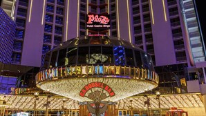 A multi-story building with a prominent sign reading "Plaza Hotel Casino Bingo" and a carousel at the ground level. - Plaza Hotel & Casino (Las Vegas)