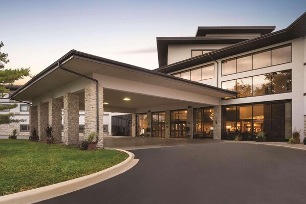 A modern hotel entrance with a covered driveway, stone pillars, and large windows. - Oneida Casino Hotel (Green Bay)