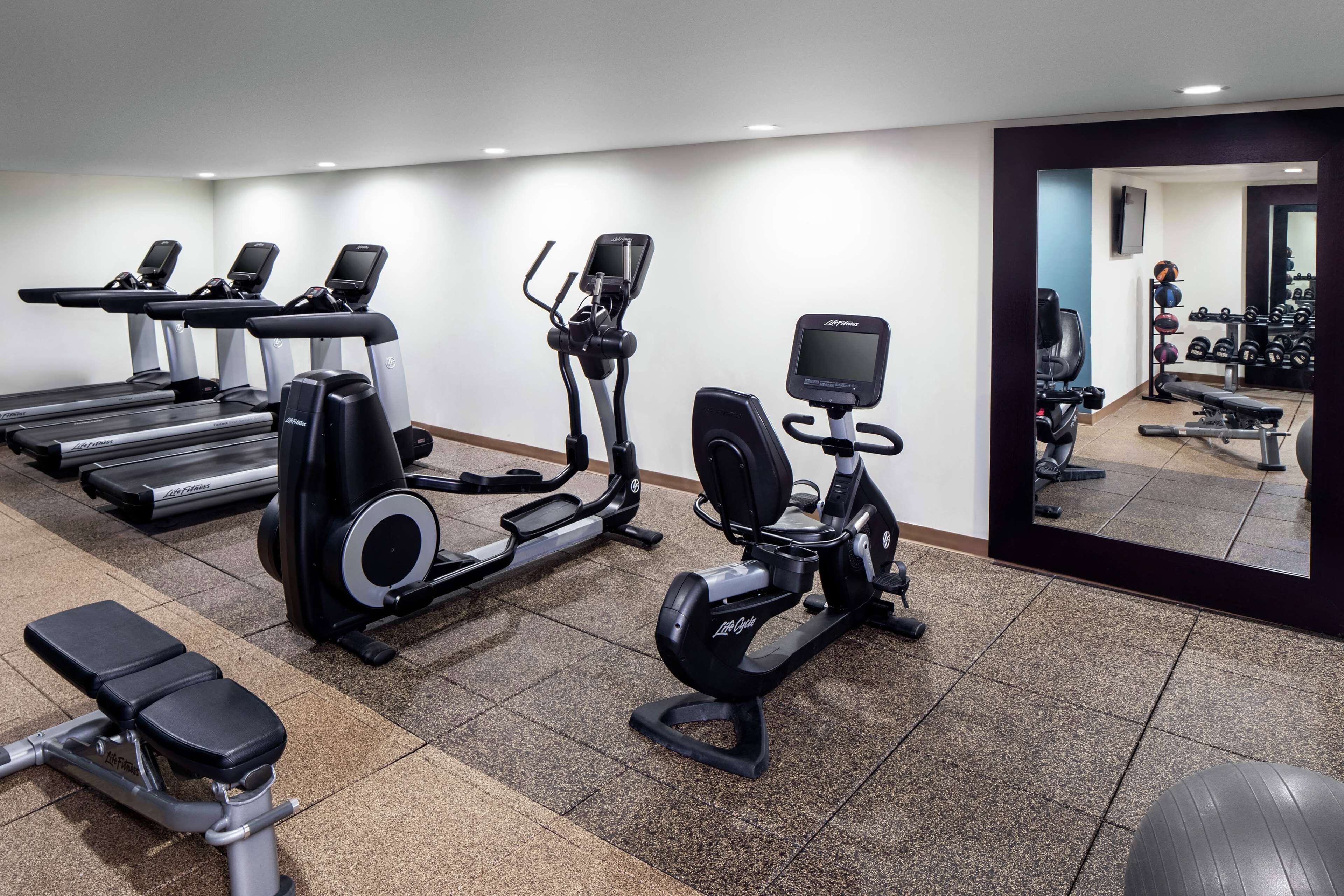 Una palestra con tapis roulant, ellittiche e una panca.