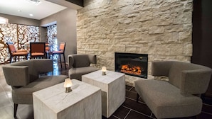 A modern lounge area with stone walls, comfortable seating, and a fireplace.