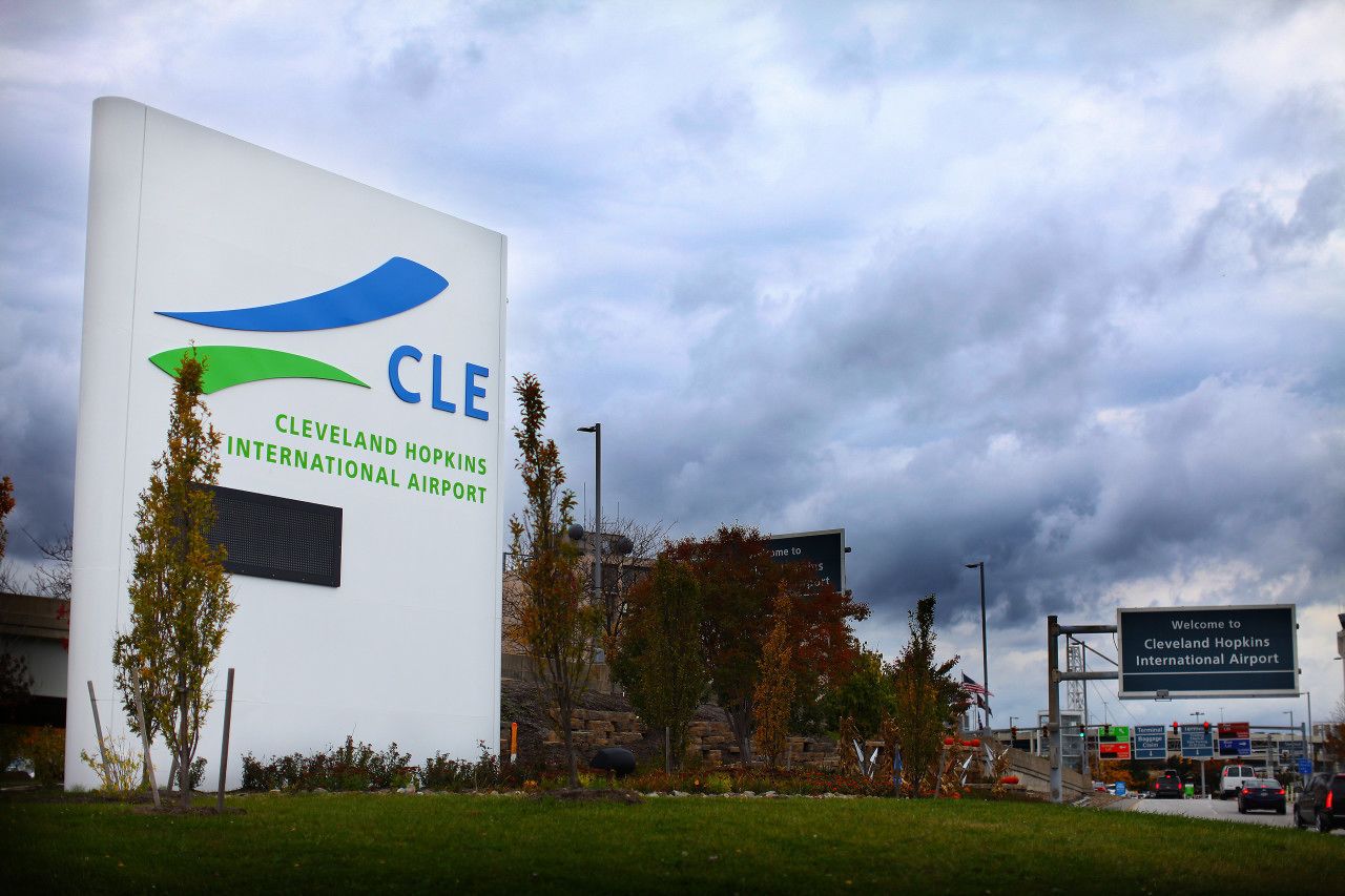 Segnaletica per l'Aeroporto Internazionale Hopkins di Cleveland, con logo blu e verde.