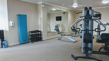 A gym with exercise equipment, a water dispenser, and a mirror.