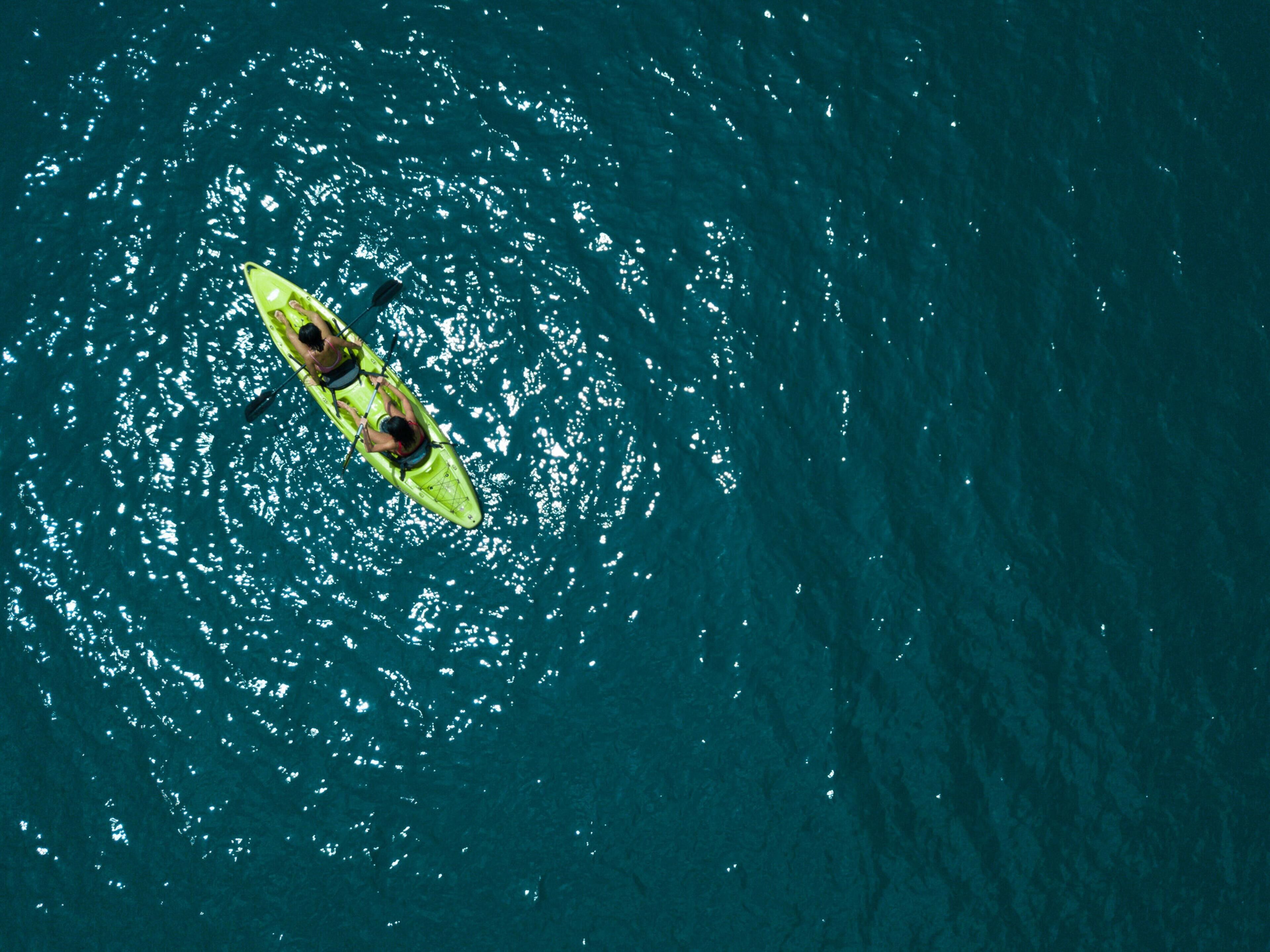 A person kayaking on a body of water.