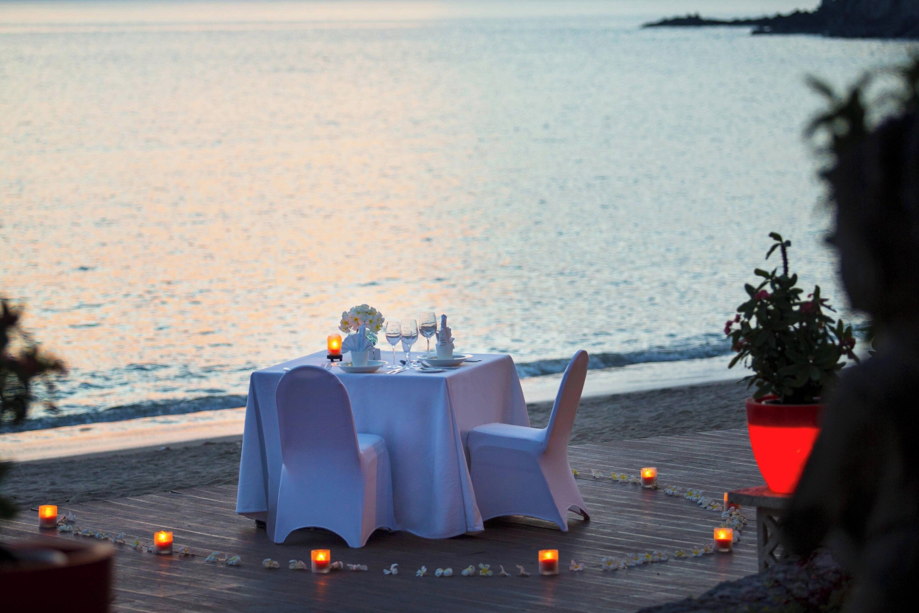Mesa para dos con vista al mar al atardecer.