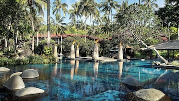 Una piscina al aire libre, sombrillas, sillones reclinables de piscina