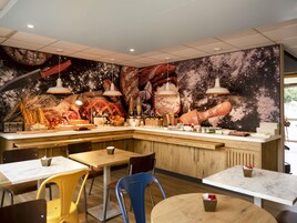 Un restaurante con una barra central, varias mesas y sillas.