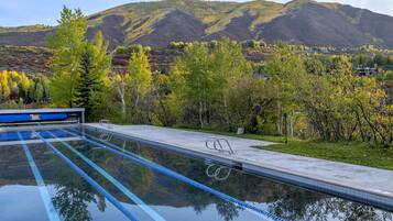 Relax by the serene pool surrounded by rolling hills and lush trees.