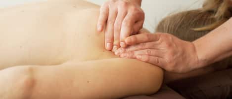 A massage therapy session with a focus on the back and shoulder area.