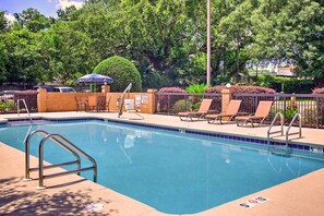 Una piscina al aire libre, sombrillas, tumbonas