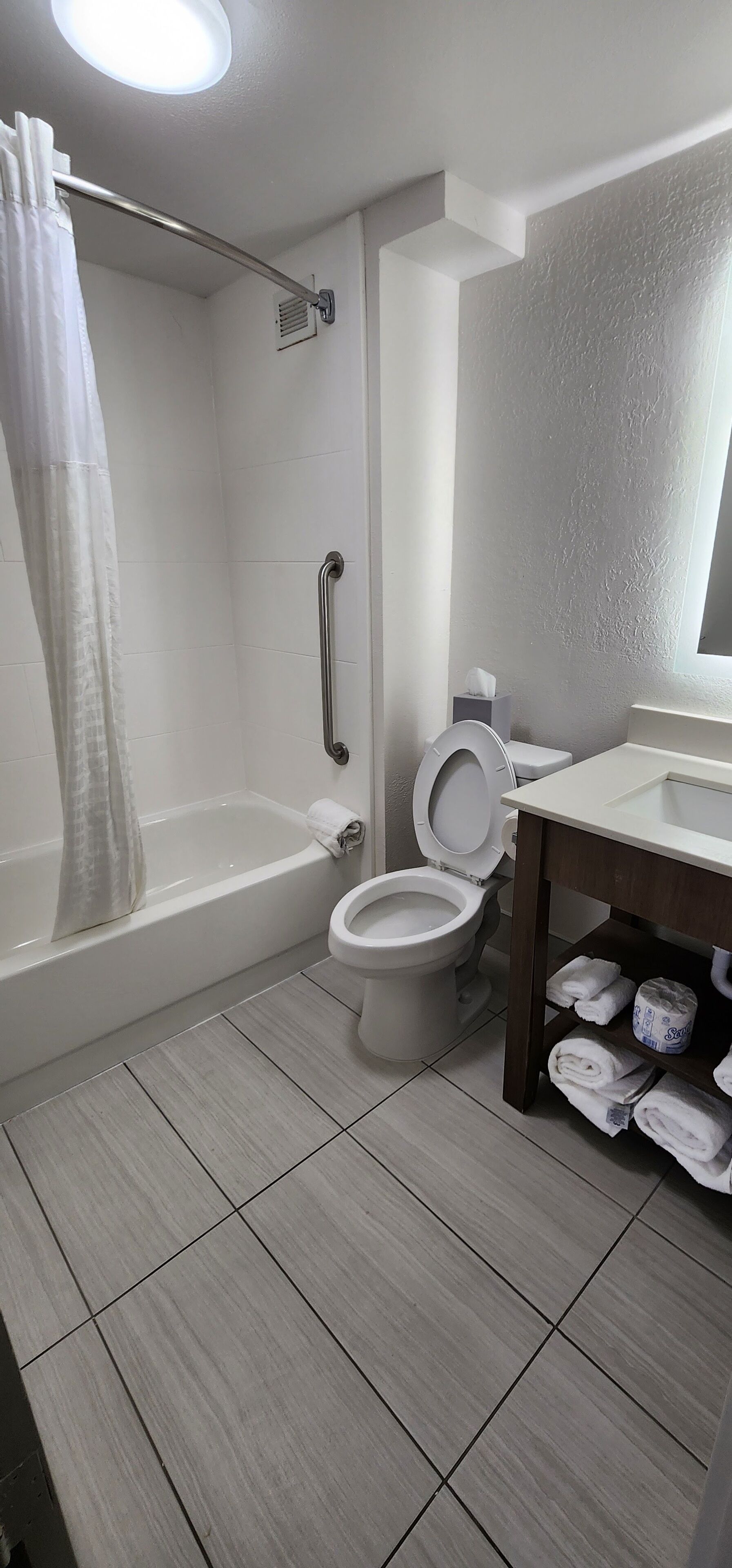 combined shower/bathtub, hydromassage showerhead, hair dryer, towels