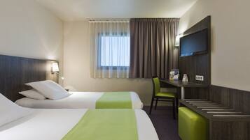 Habitación de hotel con dos camas, un escritorio, una silla, un televisor y una ventana con cortinas.