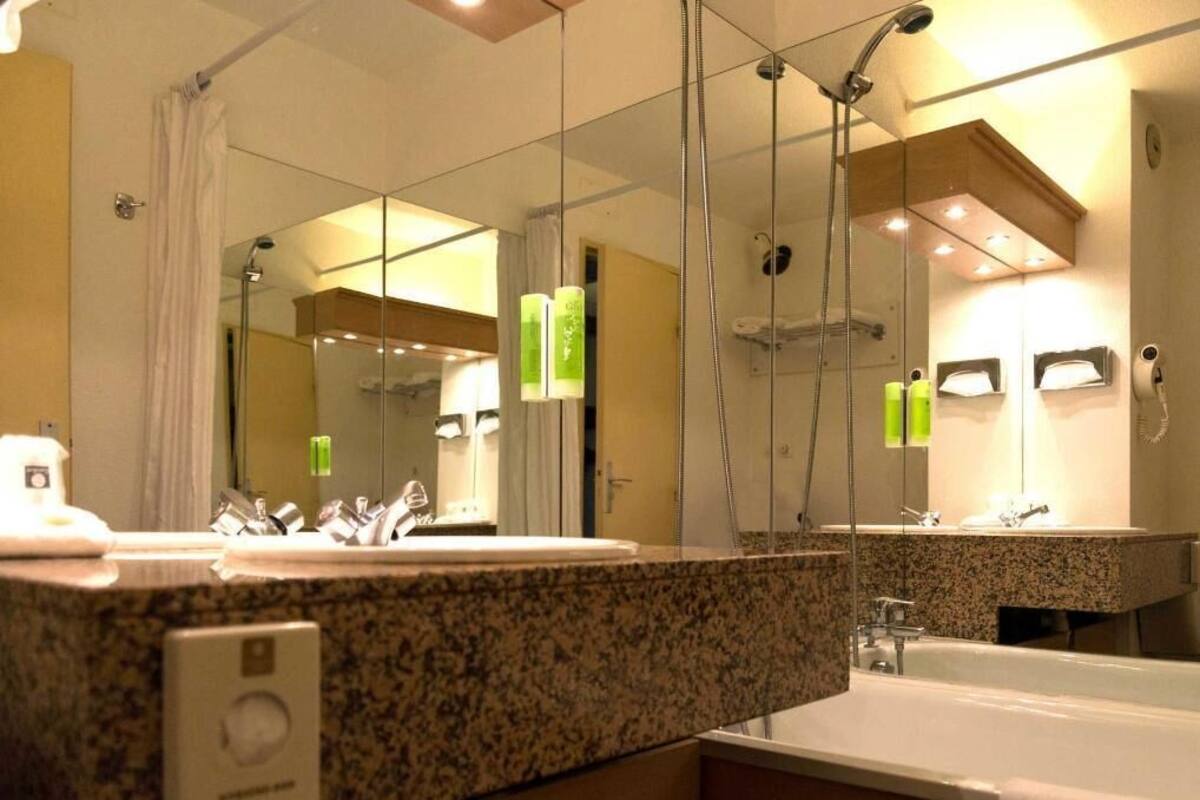 Ein Badezimmer mit zwei Waschbecken, einer Badewanne und einem großen Spiegel.
