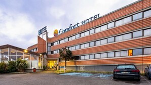 Un hôtel doté d’une façade moderne, de grandes fenêtres et d’une enseigne indiquant « Comfort Hotel ».