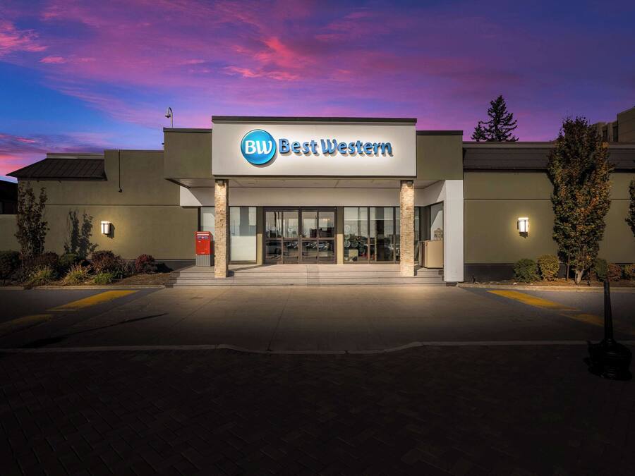 Un hotel Best Western con fachada moderna, amplia entrada de vidrio y exterior bien iluminado.