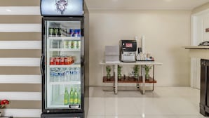 A hotel room with a minibar, a coffee machine, and a small table with potted plants. - Best Western Plus LA Mid Town Hotel (Los Angeles)