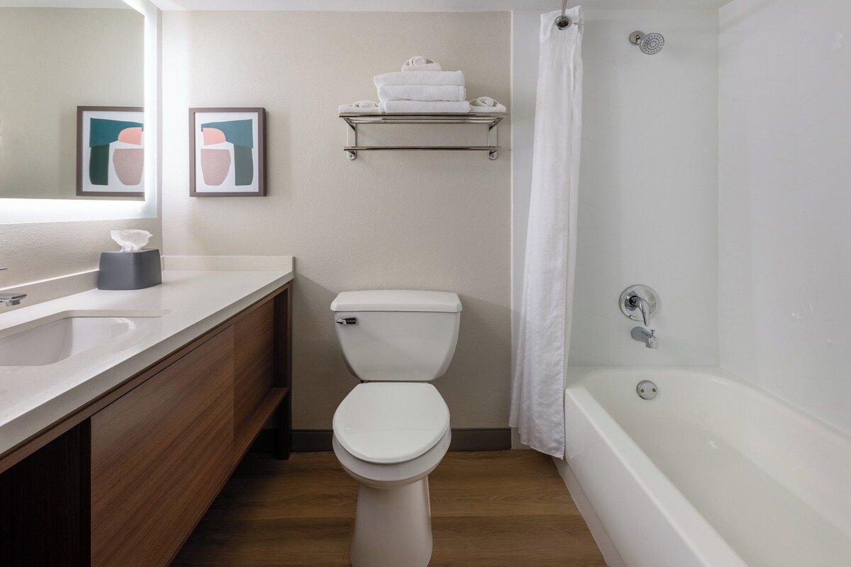 A modern bathroom with a toilet, sink, and bathtub.