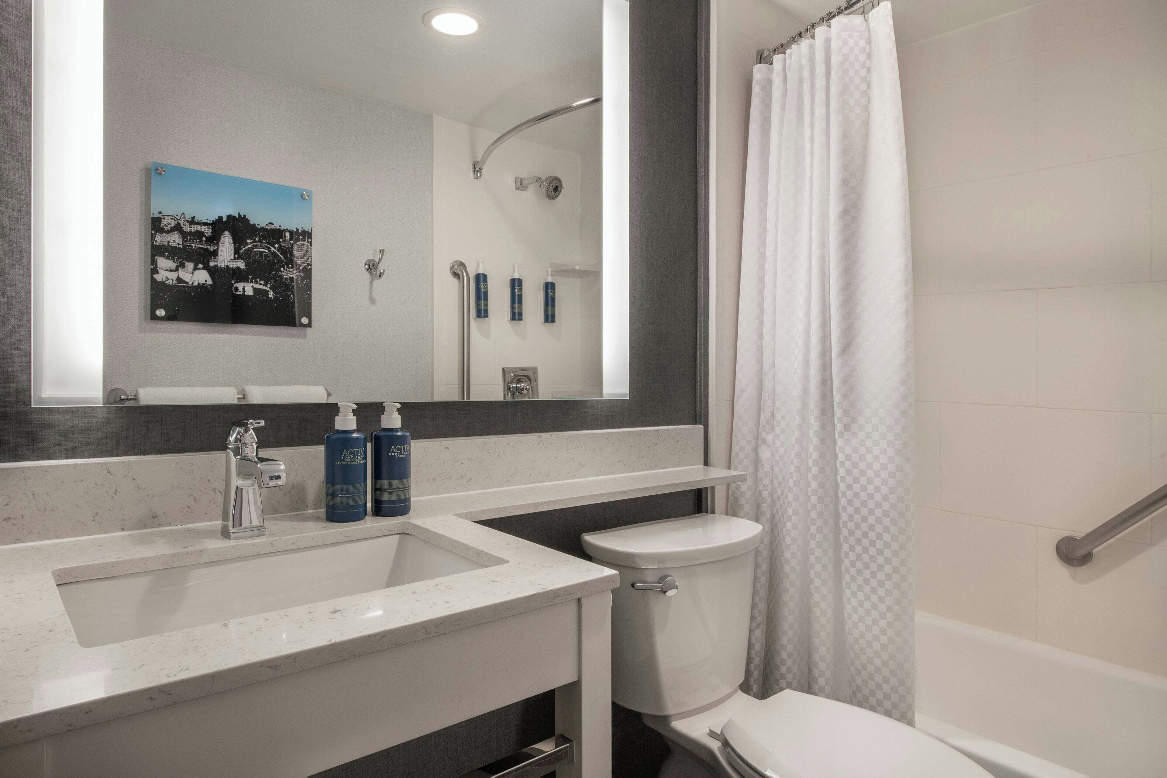 A bathroom with a sink, toilet, and shower area.