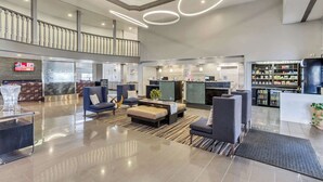 Eine geräumige Lobby mit Empfangsschalter, Sitzgelegenheiten und einer Bar.