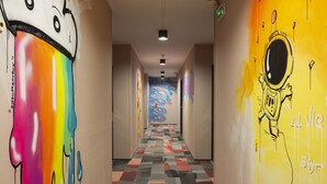 A hallway with colorful graffiti on the walls and a patterned floor. - Ibis Styles Toulouse Centre Canal du Midi (Toulouse)