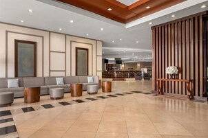 Un moderno vestíbulo con área de estar, bar y un panel decorativo de madera.