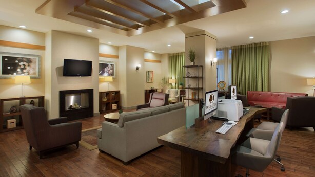 Una sala de estar moderna con chimenea, televisión y comedor con barra.