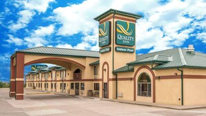 A Quality Inn with a prominent indoor pool sign, a covered entrance, and a series of rooms with a consistent architectural style.