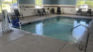 An indoor swimming pool with clear water, a lifeguard chair, and a pool ladder. - Quality Inn Raton, NM (Raton)