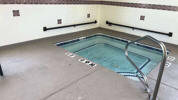 Swimmers can enjoy a safe and well-marked pool area with a depth indicator and handrails.