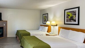 Habitación de hotel con dos camas, televisión, lámpara y cuadros en la pared.