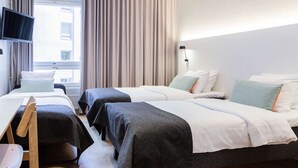 A hotel room with two beds, a desk, a chair, a TV, and a window with curtains. - Scandic Helsinki Aviapolis (Vantaa)