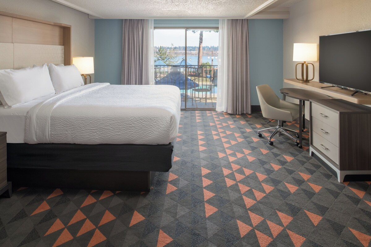 Une chambre d’hôtel équipée d’un lit, d’un bureau, d’une chaise et d’un téléviseur.
