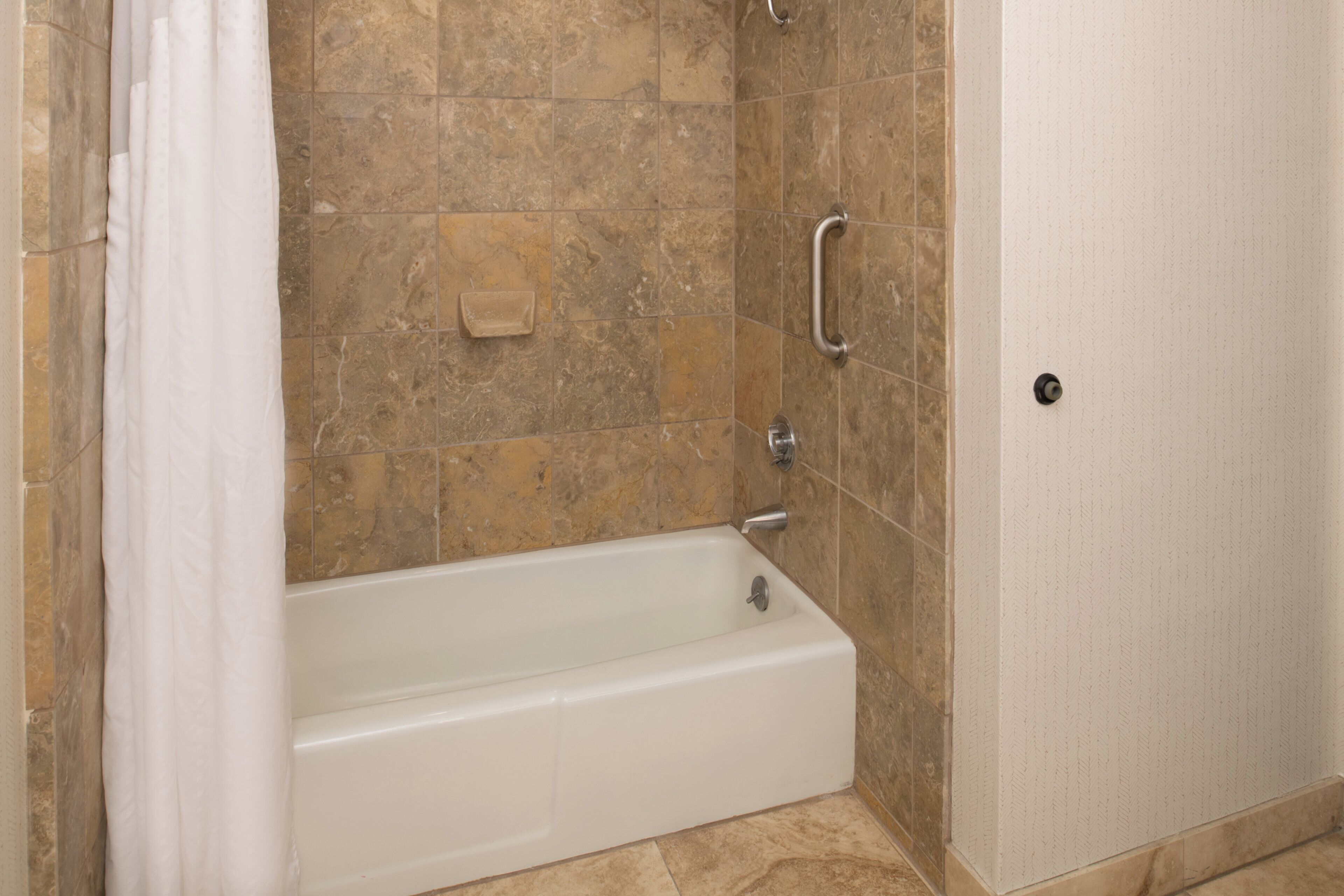 A bathroom with a bathtub, shower, and a toilet.