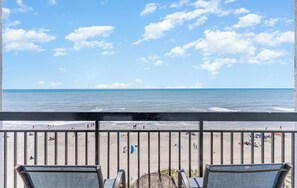 Uma varanda com vista para a praia e o oceano.