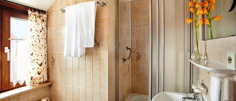 Une salle de bain avec une douche, un lavabo et un miroir.