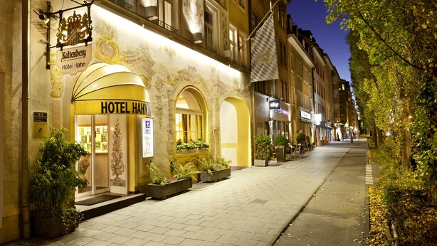 A hotel facade with a sign reading "Hotel Hahn," featuring a classical architectural style with arched windows and a yellow awning. - Hahn Hotel (Munich)