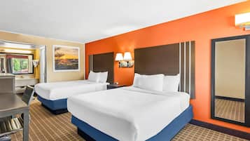 A hotel room with two beds, a desk, and a chair.