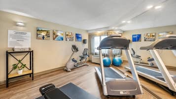 A fitness room with treadmills, exercise bikes, and a wall-mounted mirror.