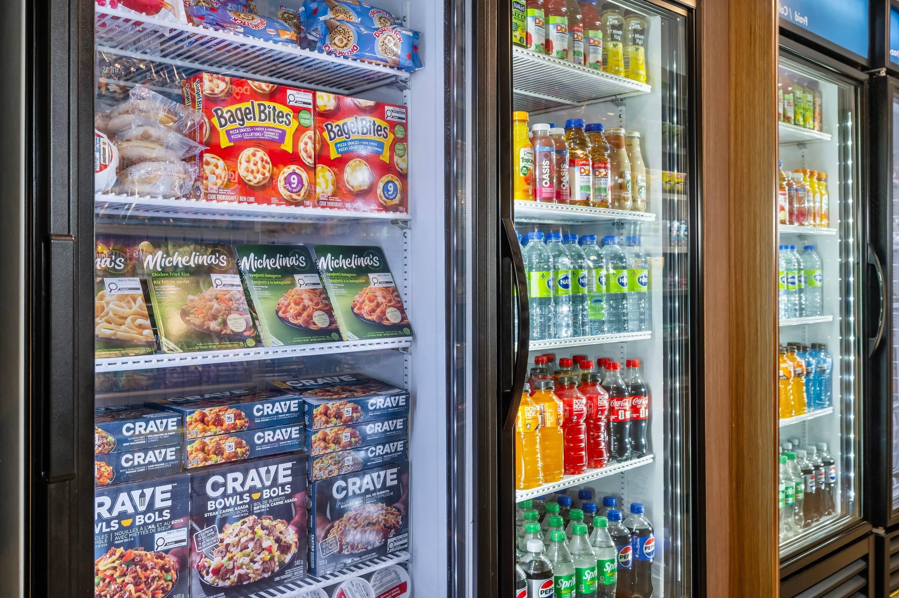 A refrigerated display case in a store with various food items and beverages.