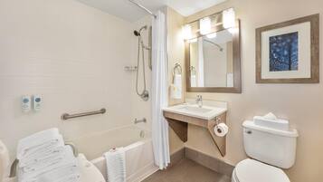 A modern bathroom with a bathtub, shower, toilet, and sink.