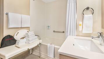 A bathroom with a shower, a sink, and a hair dryer.