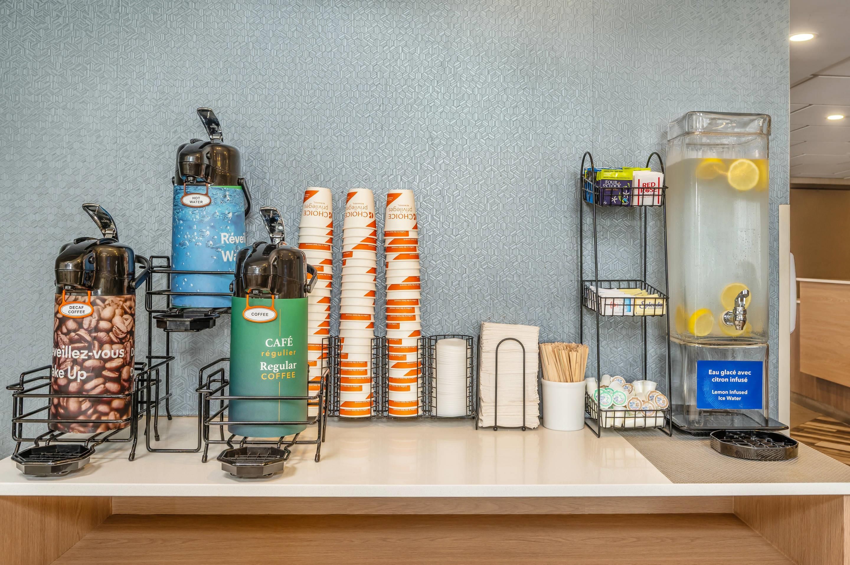 A coffee station with various coffee options, a water dispenser, and a tea station.